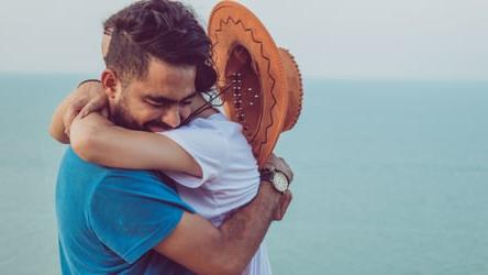 Excited couple embracing and celebrating consolidating their debt